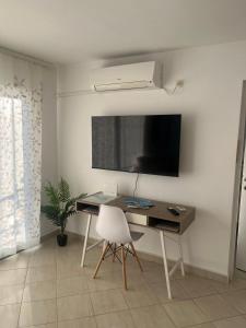 a room with a desk and a television on a wall at Apartment Tihana in Cres