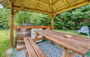 einen Picknicktisch aus Holz in einem Pavillon mit einem Herd in der Unterkunft Nice Home In Sarlat-La-Canéda in Sarlat-la-Canéda