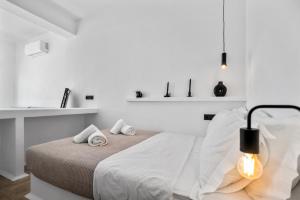 a white bedroom with a bed with two towels on it at Amenti Horizon View in Agkidia