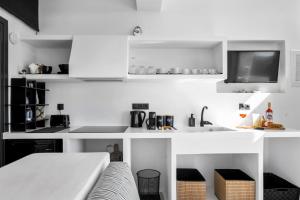 a white kitchen with a couch and a sink at Amenti Horizon View in Agkidia