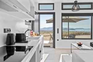 a kitchen with a view of the ocean at Amenti Horizon View in Agkidia +27 photos