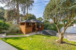 a gazebo in a garden with a tree at Ma villa chez Archie, pour des vacances bucoliques in Pyla-sur-Mer