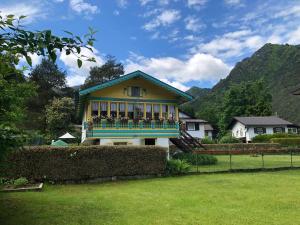 a house with a balcony with flowers on it at Bungalow Tirolese in Molina di Ledro