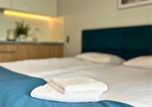 a bed with two white towels on top of it at Apartament 19 w Mielenku in Mielenko