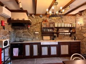 a large kitchen with a stone wall at CASA das Leiras in Vieira do Minho