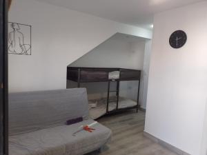 a living room with a couch and a clock on the wall at El Mirador, Villamartin, Refurbished,cot to hire, WIFI, pool, parking in Villamartin