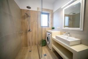 a bathroom with a sink and a washing machine at Villa Sofita Komos View in Pitsidia +84 photos