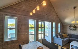 a living room with a couch and a table and windows at Nice Apartment In Auklandshamn in Vestvik