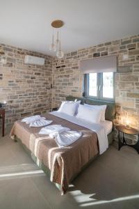 a bedroom with a large bed with a brick wall at Villa Sofita Komos View in Pitsidia