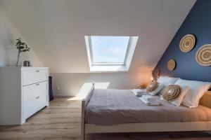 une chambre avec un lit avec un mur bleu dans l'établissement Un Air de Famille - proche de la plage, à Pleubian