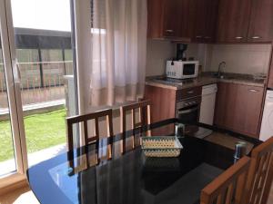 a small kitchen with a table and a microwave at Araco 1D by CONFORTSKY in Pas de la Casa