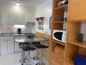 a kitchen with white cabinets and a counter with stools at FB 563 by CONFORTSKY in Pas de la Casa