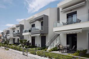 an apartment building with balconies and tables on the balcony at Erato Residential Complex in Ofrínion