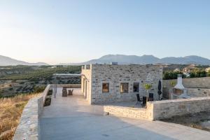 a stone house with a view of the mountains at Villa Sofita Komos View in Pitsidia