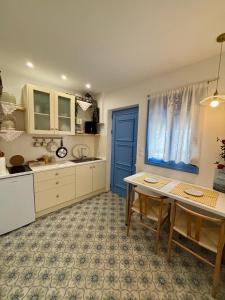 a kitchen with a table and a blue door at Álas Holiday Home in Archangelos +26 photos