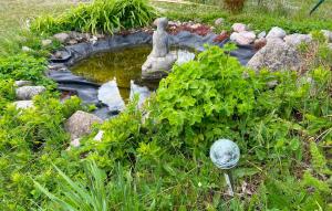 un pequeño estanque con una estatua en un jardín en 5 Bedroom Cozy Home In Gotlands Tofta, en Gnisvärd