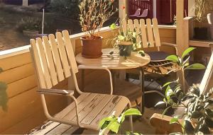 two chairs and a table on a porch with plants at 1 Bedroom Amazing Home In Värmdö in Värmdö +15 photos