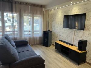 a living room with a couch and a flat screen tv at GRAN COLLBLANC by CONFORTSKY in Pas de la Casa