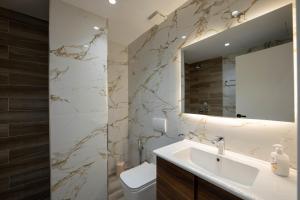 a bathroom with a sink and a mirror at Regal Luxury Apartments in Sarandë