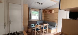 a small room with a bench and a table and chairs at Mobile Home en Provence in La Roque-dʼAnthéron