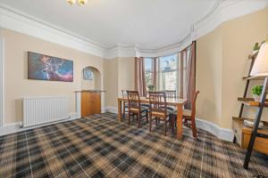 Un comedor con mesa y sillas en mySTAYINN Cedar Villa Guest House, en Inverness