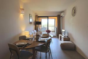 a dining room with a table and chairs in a room at U Mare - T2 cabine avec vue mer, plage & piscine in Pianottoli-Caldarello +22 photos