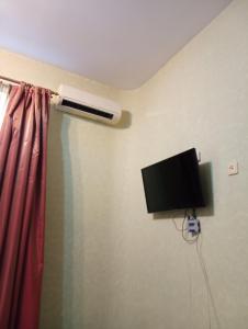 a room with a tv and a air conditioner on the wall at Welcome Apartments in Odessa in Odesa