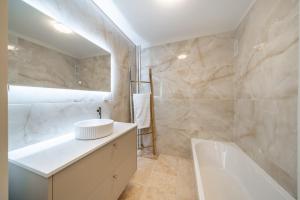 ein Badezimmer mit einer weißen Badewanne und einem Waschbecken in der Unterkunft Two Bedroom Appartment - Cannes in Cannes + 10 Fotos