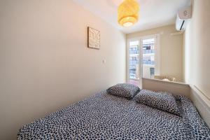 ein Schlafzimmer mit einem Bett mit zwei Kissen und einem Fenster in der Unterkunft Two Bedroom Appartment - Cannes in Cannes