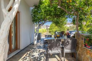 アギア・ペラギアにあるAriella, Cozy Apartment Near the Beachの木々のあるパティオ(テーブル、椅子付)