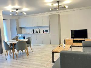a living room with a table and chairs and a kitchen at Cozy North 35 in Cluj-Napoca