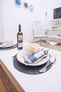 a table with a bowl of food and a bottle of wine at 1BR hidden gem at the Nook in Gibraltar