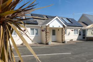 a row of houses with solar panels on their roofs at Fern Cottage - Dog Friendly Cottage with Hot Tub in Begelly