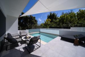 a patio with a table and chairs next to a swimming pool at Azur Hotel in Athens