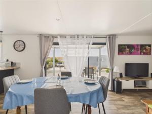 a dining room with a blue table and chairs at Chalet pour 6, residence avec piscine in Brétignolles-sur-Mer