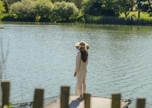 a woman standing on a dock near a body of water at Hôtel Maison Chiberta in Anglet