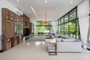 un salon avec un canapé et une télévision dans l'établissement Huge Pool Villa with Private Lake 4BR 10 Persons, à Ban Huai Yai