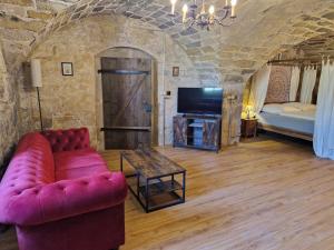 un salon avec un canapé, une télévision et un lit dans l'établissement Schlossgut Franken - Schlossapartment Iring, à Redwitz an der Rodach