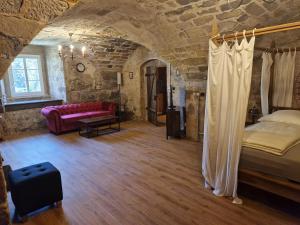 une chambre avec un lit et un canapé dans une pièce dans l'établissement Schlossgut Franken - Schlossapartment Iring, à Redwitz an der Rodach
