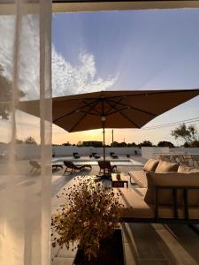 a patio with an umbrella and couches on a roof at Villa AM in Donje Biljane