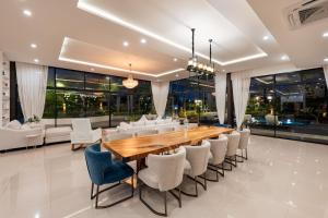 une salle à manger avec une longue table en bois et des chaises dans l'établissement Huge Pool Villa with Private Lake 4BR 10 Persons, à Ban Huai Yai