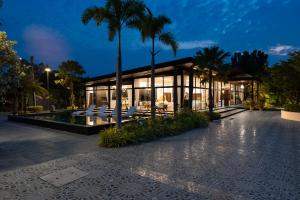 un bâtiment avec des chaises blanches et des palmiers la nuit dans l'établissement Huge Pool Villa with Private Lake 4BR 10 Persons, à Ban Huai Yai