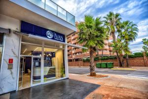 a building with a palm tree in front of it at Casa Yuliia Ivan Luxury Homes 2ªPlta Norte 1ªLinea in Oropesa del Mar