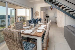 a dining room with a long table and chairs at Vermont Vista - With Pool in Hermanus