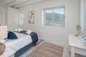 a white bedroom with a bed and a window at Vermont Vista - With Pool in Hermanus +36 photos