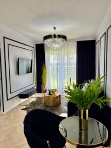 a living room with a table and chairs and a chandelier at Just Unique black in Poznań