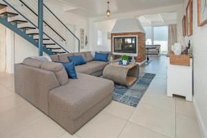 a living room with a couch and a staircase at Vermont Vista - With Pool in Hermanus