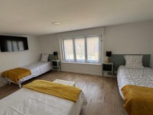 a bedroom with two beds and a window at Le Fournil in Fiennes