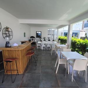 un restaurante con mesas blancas y sillas blancas en Villa à louer, en Saly Portudal