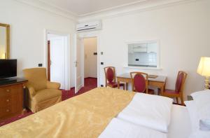 a hotel room with a bed and a table and chairs at Hotel Bologna in Prague